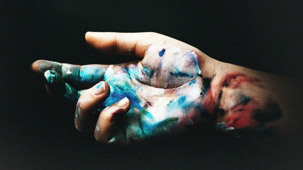 A hand with paint splatters