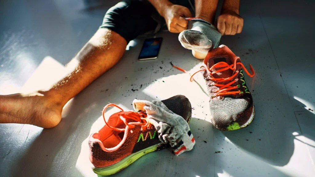 Male laces up workout shoes